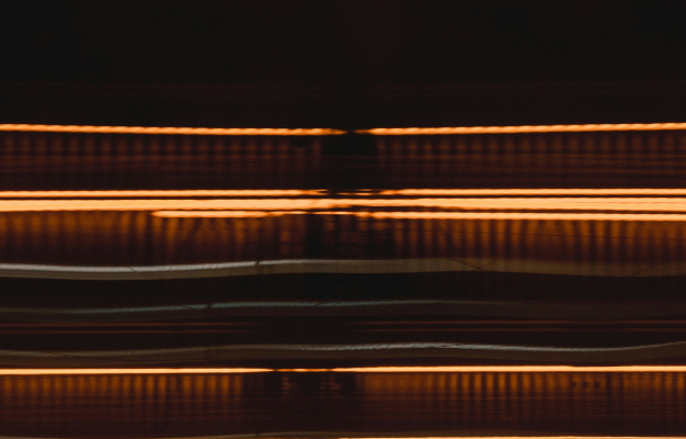 Abstrakte Lichtlinien in warmen Farbtönen als visuelle Darstellung von Geschwindigkeit, Prozessdynamik und effizientem Recruiting bei Dashing.